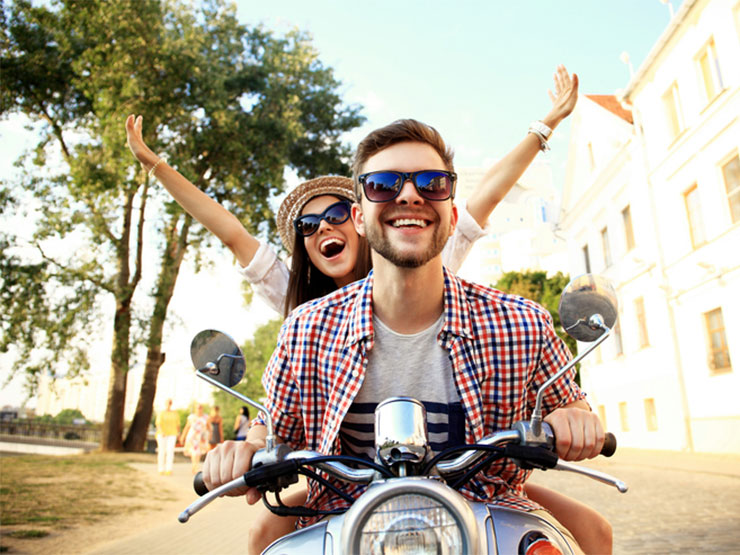 Smiling young people on scooter.