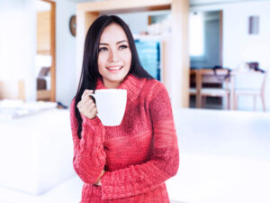 Woman in red top holding a mug.